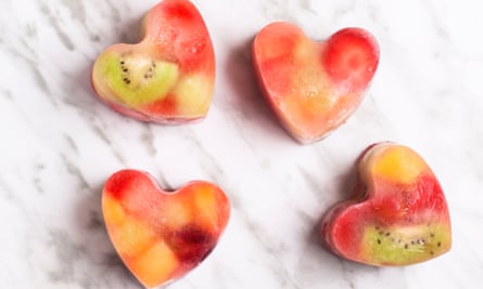 Cubitos de hielo en forma de corazón con trozos de fruta congelada
